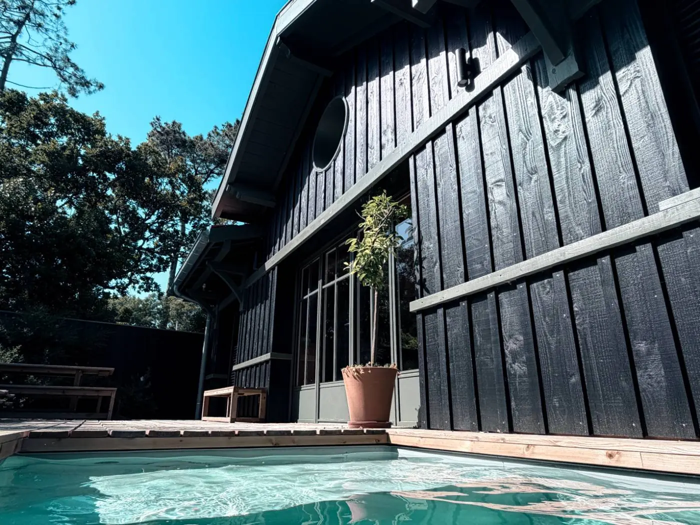 Façade en bois noir et piscine